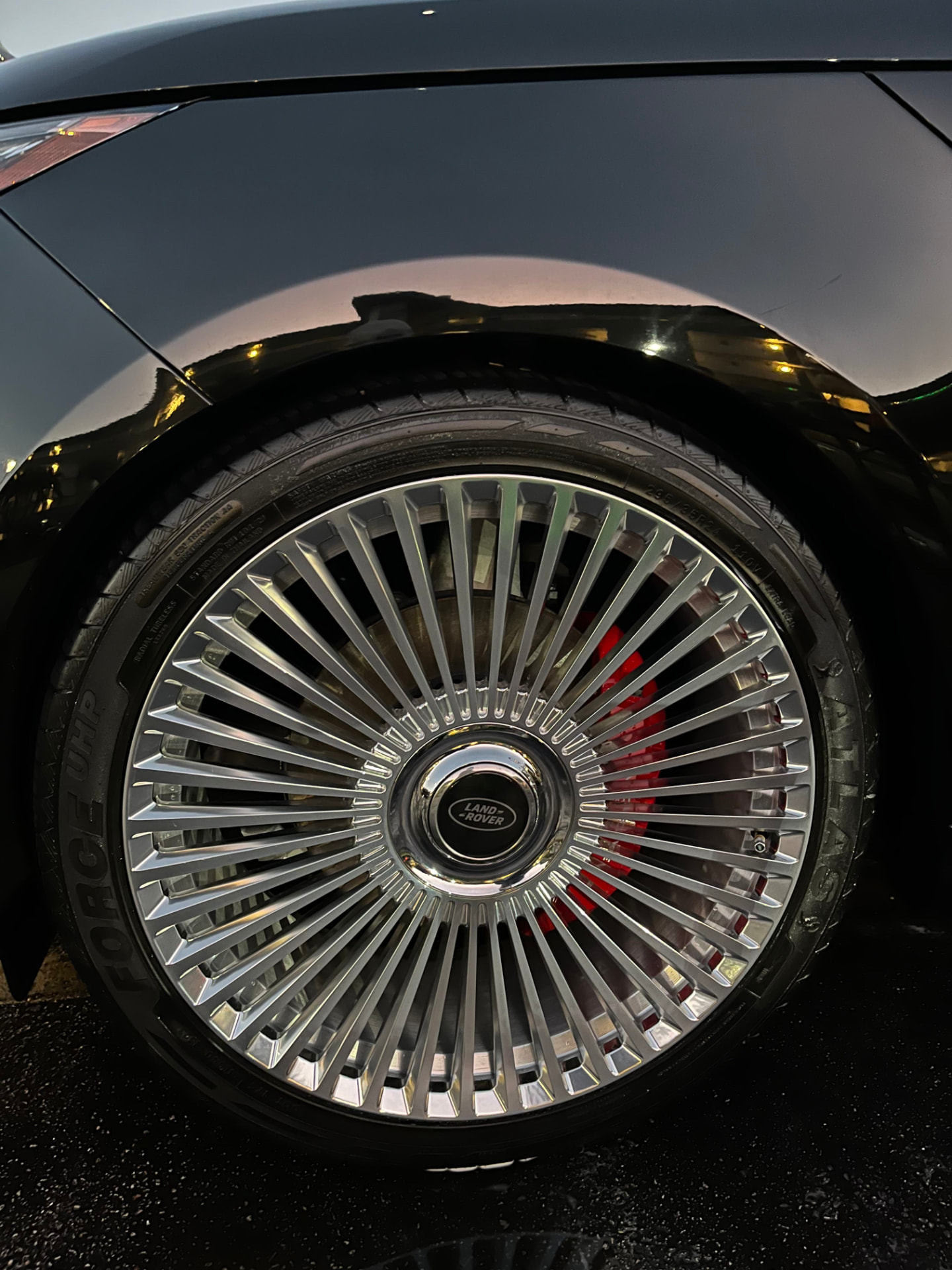 Wheel and fender arch at dusk on mirror-black paint